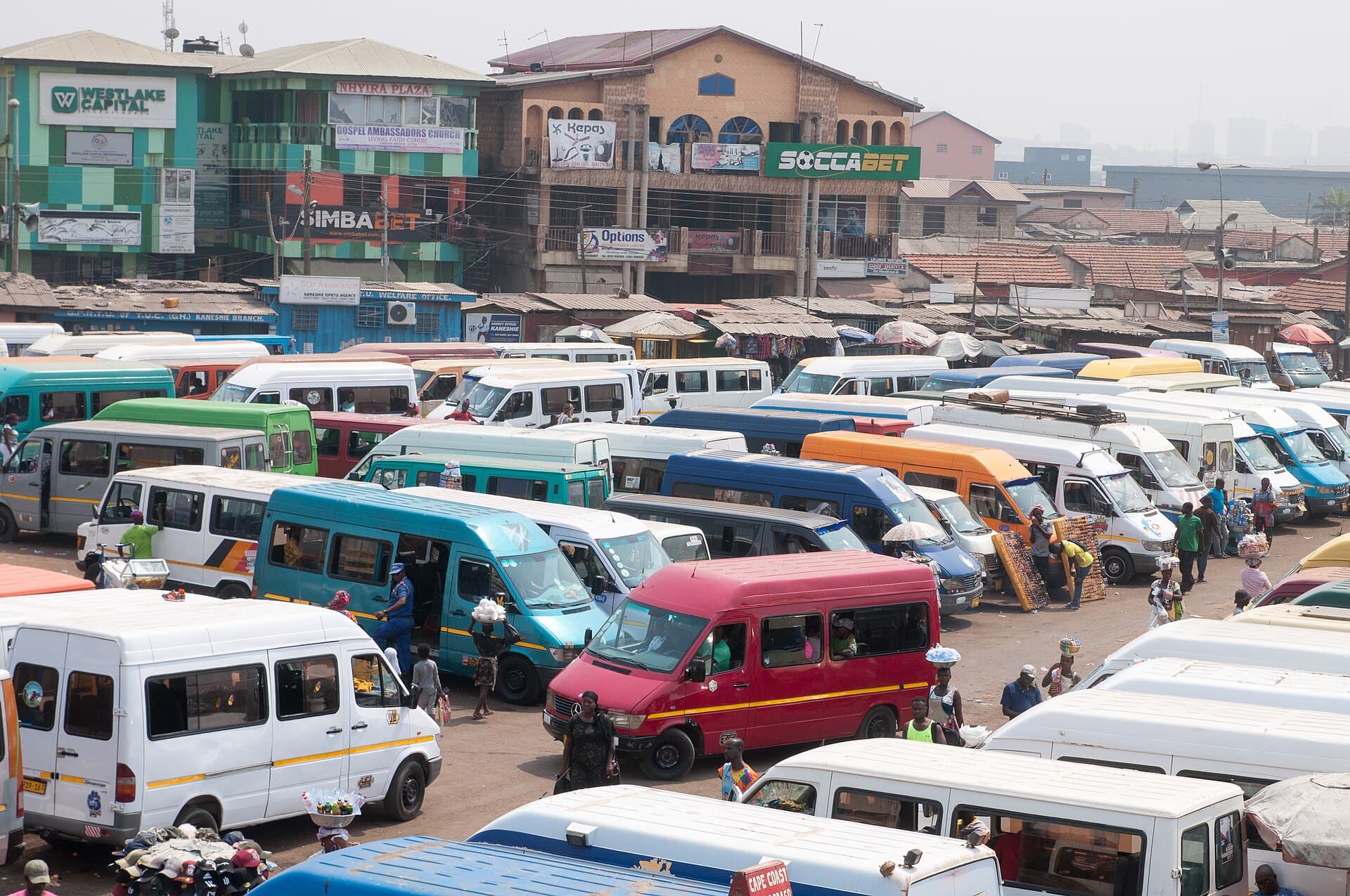 Trotro minibuses packed into the Kaneshie station in Accra, viewed from a footbridge
